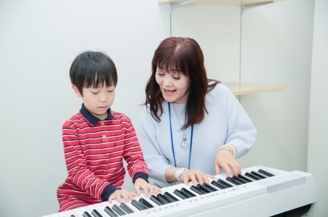 ピアノレッスンを行う生徒と講師の写真